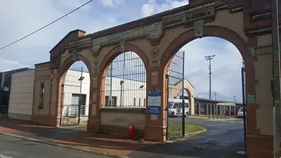 Arched brick gateway of the ESAT de la Couronnerie