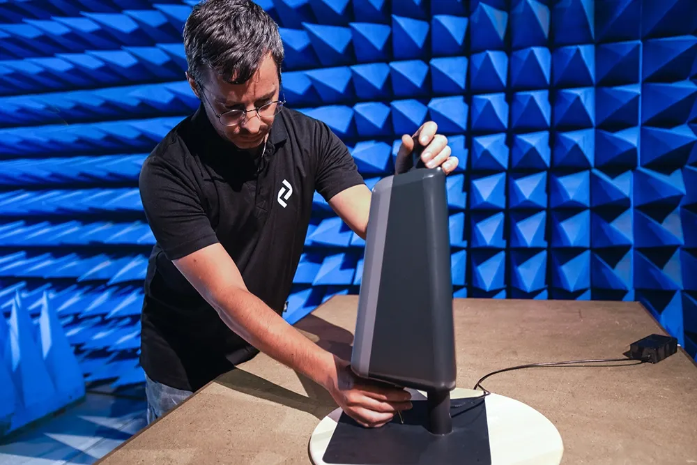 Altyor engineer setting up a measurement antenna in an anechoic chamber with blue foam walls