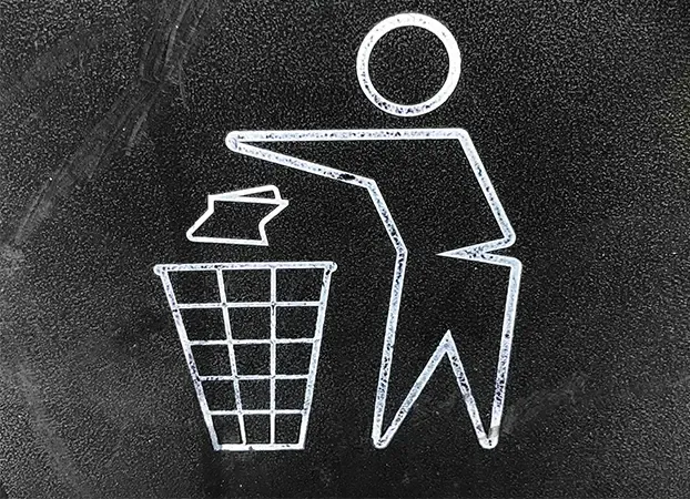 White pictogram of a person throwing paper into a bin, painted on a black background
