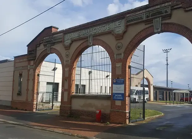 Portail en briques à trois arches portant l’inscription « Usine automobile », entrée d’un site d’ESAT